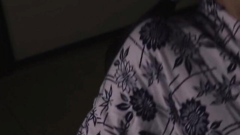 Close-up of wrinkled white floral-patterned blouse fabric texture on skin.
