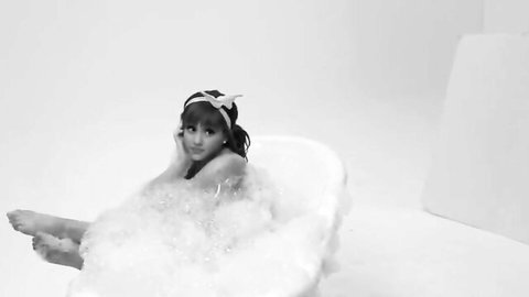 Young Ariana Grande in bubbly bathtub, playful nude tease