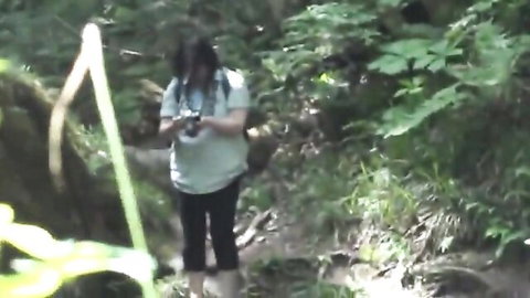 Asian woman hikes and prepares to strip outdoors in forest