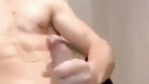 Muscular young stud with ripped abs strokes his thick erect cock in solo handjob