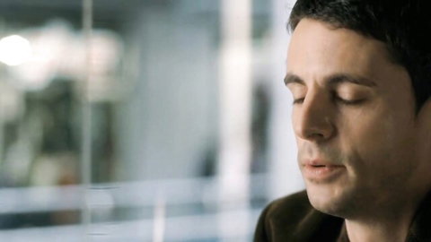 Matthew Goode as thoughtful man in suit, eyes closed, Burning Man (2011) scene