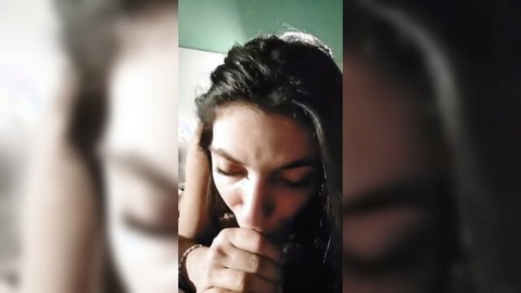 Close-up of brunette woman performing intense blowjob, dark hair and sultry expression