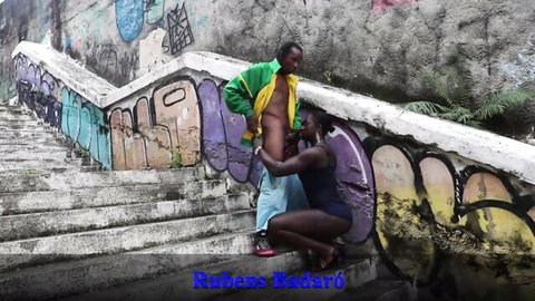 Ebony woman in swimsuit kneels for outdoor blowjob on man in daylight