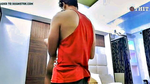 Indian man in red tank top and shorts, back view in romantic setup