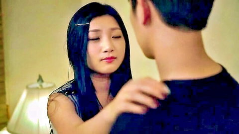 Asian woman in tank top touching man's shoulder seductively