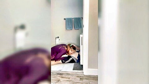 Blonde in purple lingerie kneels sucking cock in bathroom