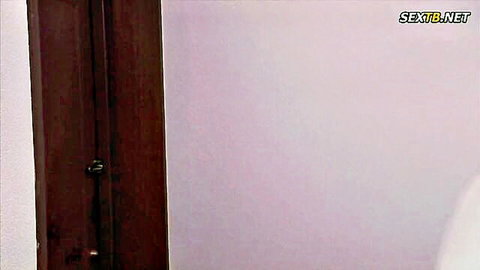 Empty pink-walled room with wooden door frame in Asian porn video