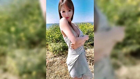 Busty Asian babe smiles with big tits visible through sheer gray slip dress posing outdoors