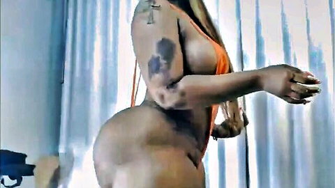 Sexy black BBW with tattoos posing in revealing orange bikini, big ass and cleavage
