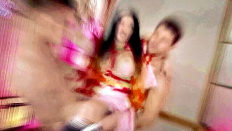 Blurry cosplay teen in pink kimono with muscular man in passionate hug