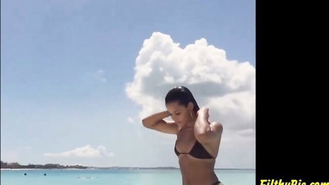 Katya Elise Henry in black bikini on beach, wet hair, sexy pose