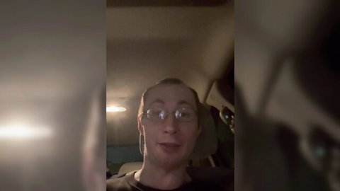 Blurry selfie of smiling man with glasses in car for JOI video