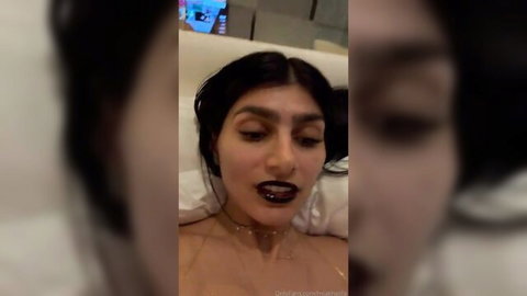 Sexy olive-skinned Arab brunette with big tits and dark lipstick teases topless on bed