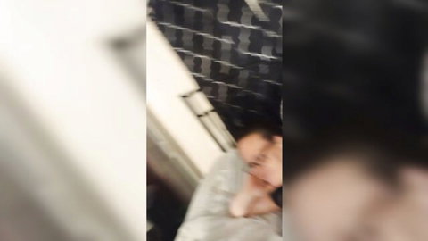 Blurry amateur shot of babe lying partially covered by sheet in tiled bathroom