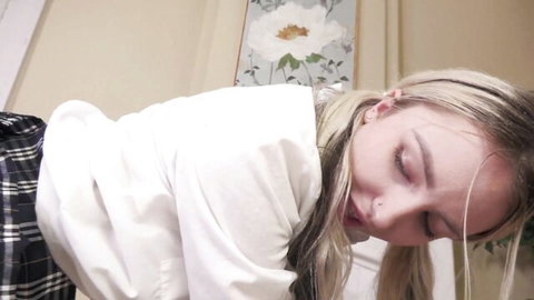Young blonde Britt Blair in plaid skirt and blouse, face in ecstasy