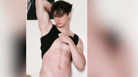 Young athletic twink pulling open black tank top exposing ripped bare chest and abs in solo striptease