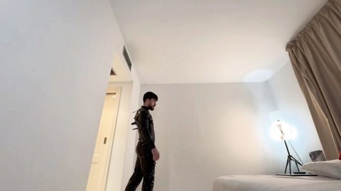 Max Dennison in tight black latex suit, intense side pose for psychotic rump punching fetish video