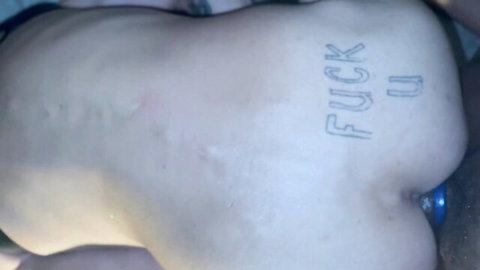 Pale guy's 'FUCK ME' tattooed ass with blue anal plug inserted