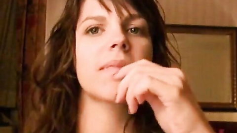 Seductive brunette beauty with plump lips fingers her mouth teasingly