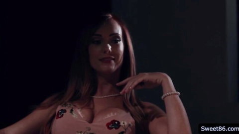 Dani Jensen in low-cut floral dress, showing big cleavage and posing seductively