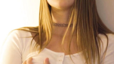 Christie Stevens in white tank top and daddy choker, showing cleavage tease