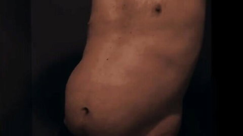 Close-up of pale man's shirtless protruding belly and deep navel in solo tease