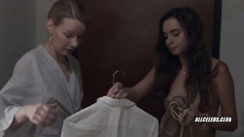 Sandra Huller in robe with topless Ingrid Bisu holding shirt in Toni Erdmann scene