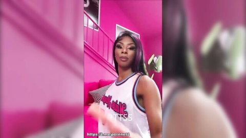 Seductive Black woman with purple hair in Bad Bitch tank top posing confidently