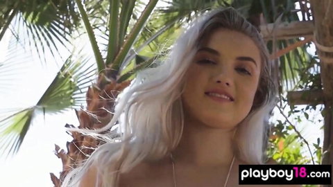 Smiling blonde teen showing off curves outdoors by palm trees