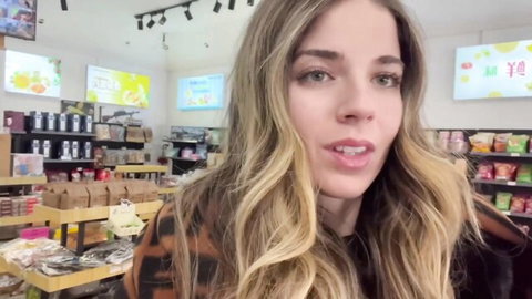 Blonde traveler smiling in Chinese market, teasing adventure abroad