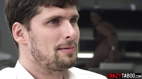 Handsome bearded man in white shirt smirking while watching lingerie babe in background