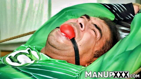 Muscular jock in green superhero suit bound and ball-gagged in kinky scene