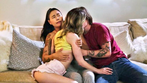 Passionate threesome with Asian and blonde women embracing tattooed man