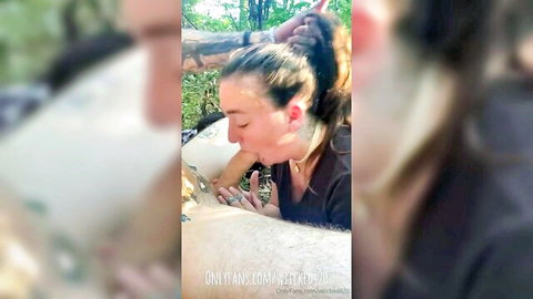 Brunette woman giving outdoor blowjob to tattooed man