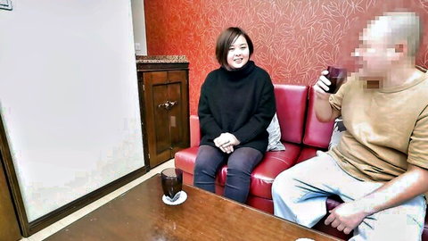Asian woman in black turtleneck with man on couch, rental wife tease