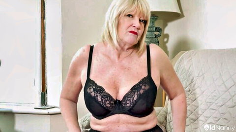 Mature blonde with huge tits spilling out of black lace bra teasing cleavage