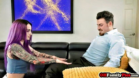 Val Steele with purple hair and tattoos reaches for man's lap in teasing apology scene