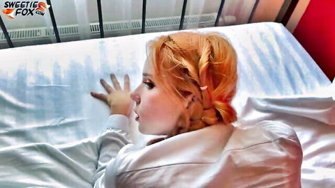 Seductive redhead Russian babe lounging on bed in white top