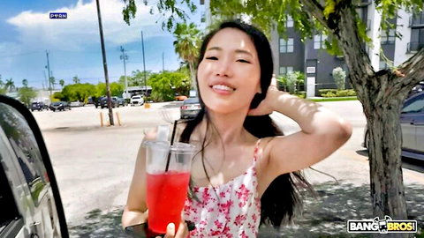 Kiki King smiling with red drinks in pink floral dress on BangBus