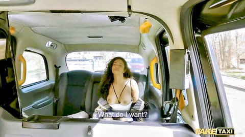 Curly-haired brunette in black bra in taxi, eyes closed in pleasure