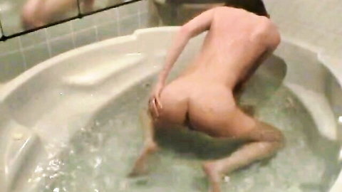 Skinny naked trans babe with small ass and dangling cock kneels bent over in wet bathtub