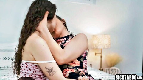 Passionate lesbian kiss between curly-haired brunette and slim woman in floral dresses