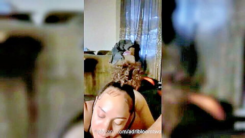 Ebony woman with curly ponytail lying topless, seductive expression