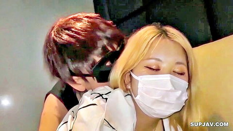 Masked Asian couple in intimate embrace, blonde woman and redhead man