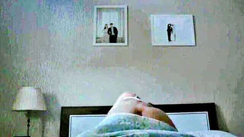 Young woman nude on bed, ass up from behind view