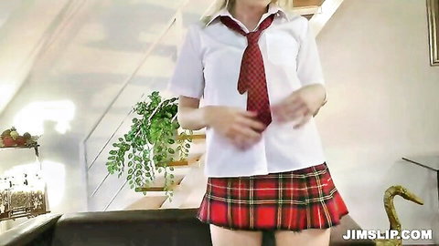 Blonde teen in schoolgirl uniform with plaid skirt and red tie posing indoors