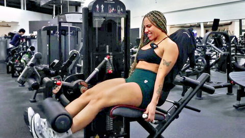Mixed-race fitness model with braids building thick horse legs in gym leg day vlog