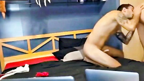Naked tattooed man licks wet pussy between spread legs on bedroom bed