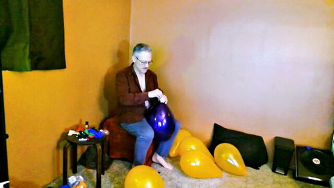 Old daddy with gray hair holding purple balloon amid yellow ones, balloon fetish tease