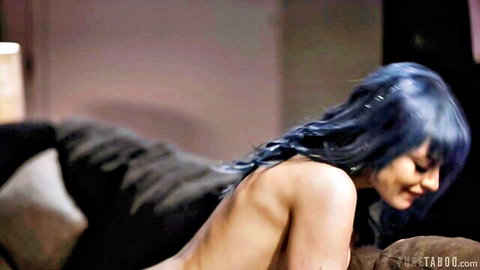 Jewelz Blu nude with blue hair, seductive side pose on dark surface